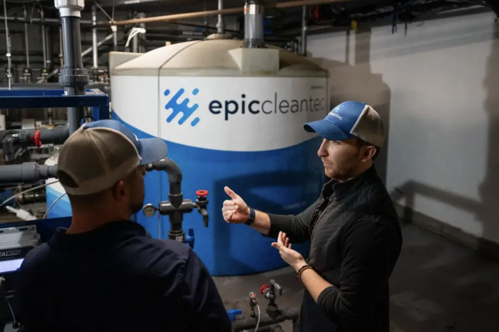 Aaron Tartakovsky, Epic Cleantec CEO, speaks with employee in front of water reuse tank